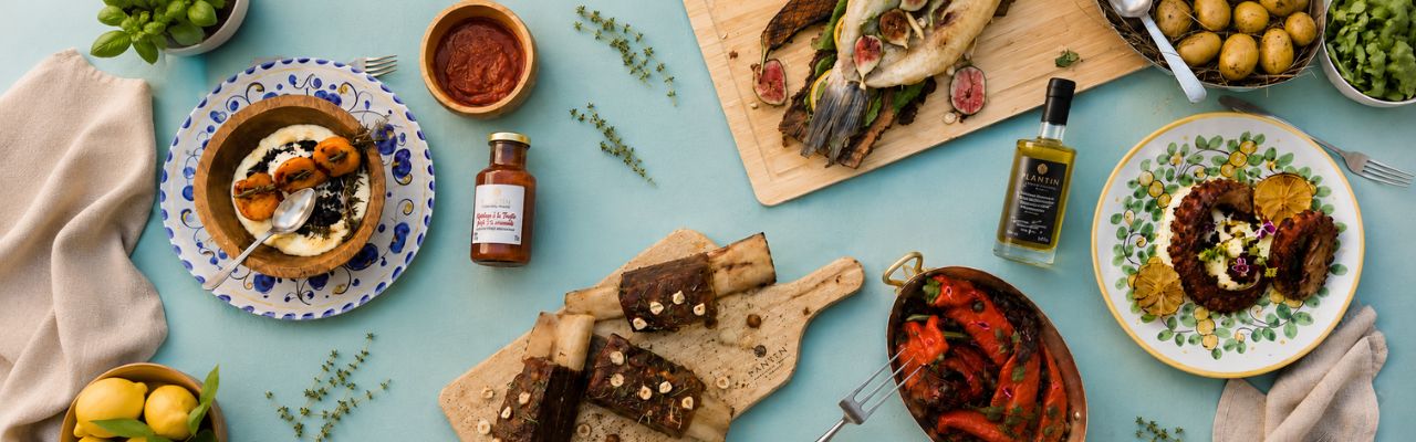 Table gourmande estivale avec recettes à la truffe d'été Plantin : poisson rôti, poulpe grillé, travers de bœuf, huile d'olive à la truffe noire et ketchup à la truffe.